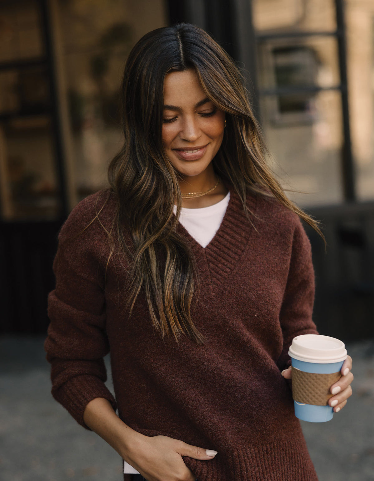 Homebound V-Neck Sweater in Spiced Brandy — outdoor view with coffee on model